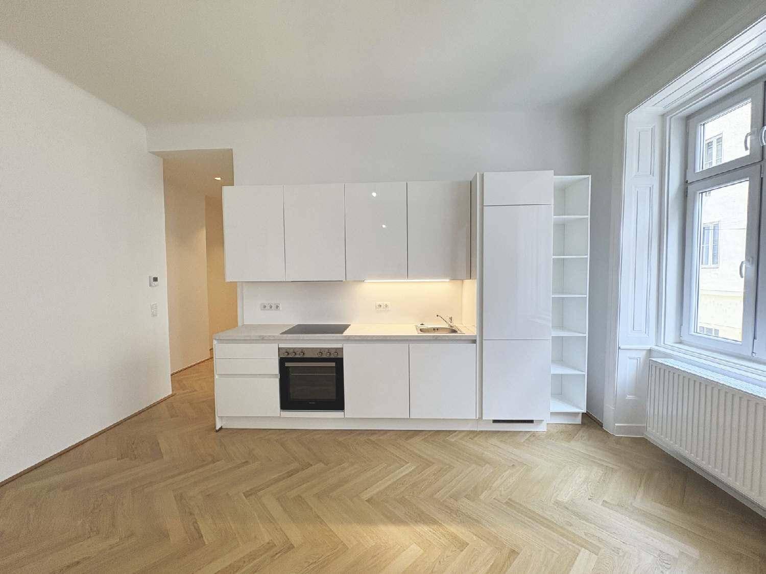 Moderne, weiße Einbauküche mit glänzenden Fronten, integriertem Backofen und ausreichend Stauraum.