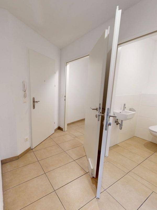Eingangsbereich mit Fliesenboden und Zugang zu einem Gäste-WC.