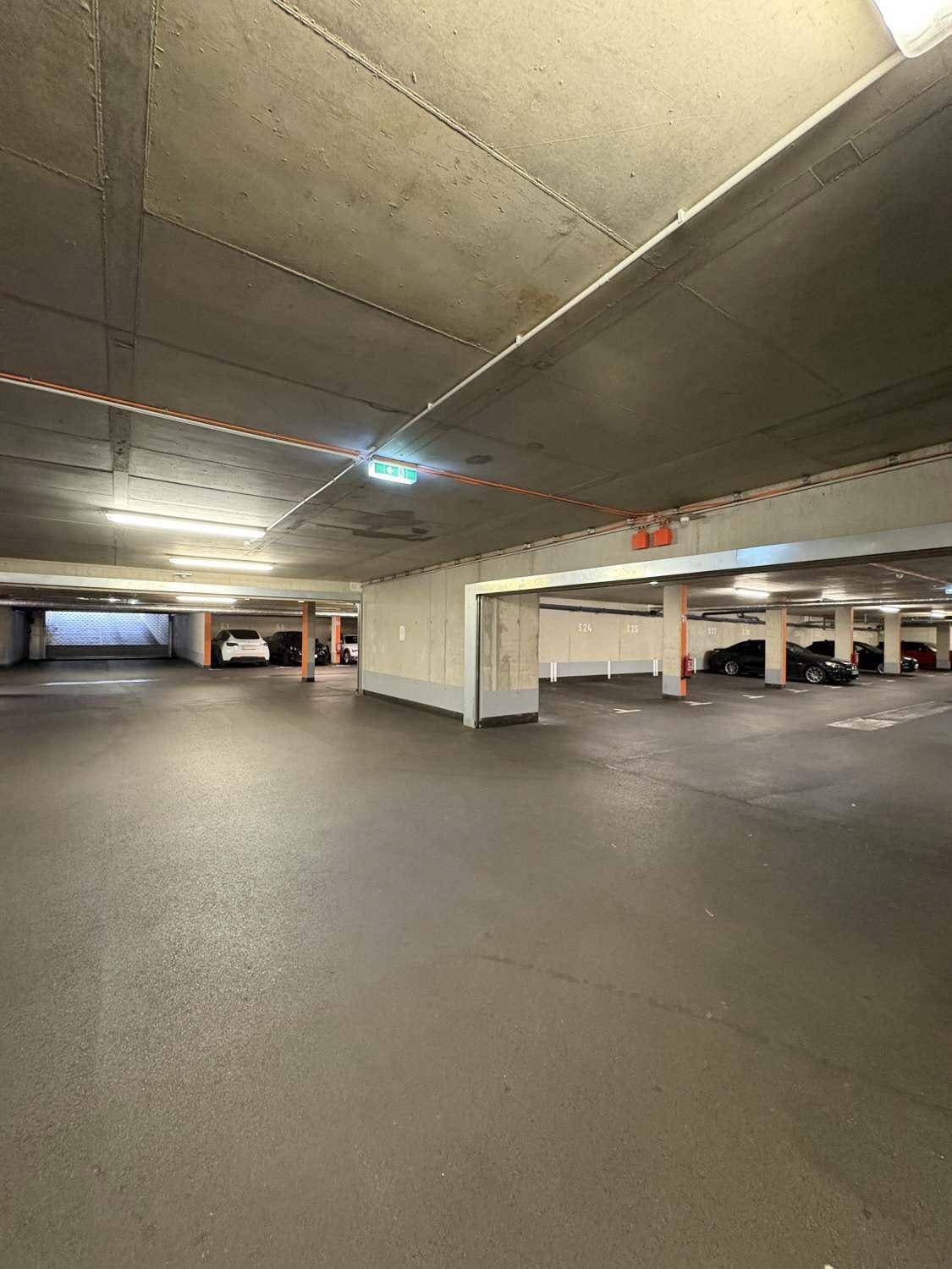Saubere Tiefgarage mit breiten Fahrwegen und vielen freien Stellplätzen.