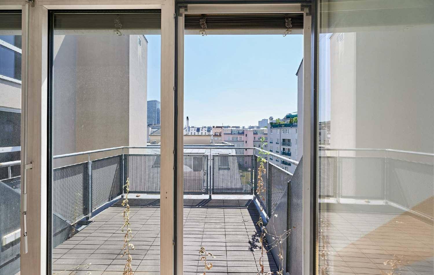 Dachterrasse mit Holzboden und Metallgeländer, bietet einen weiten Blick über die Stadt.