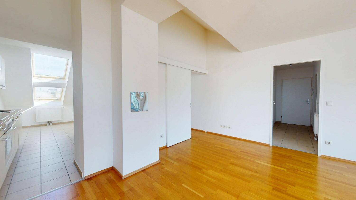 Übergangsbereich zwischen Wohnraum und Küche mit Holzboden und Fliesen.