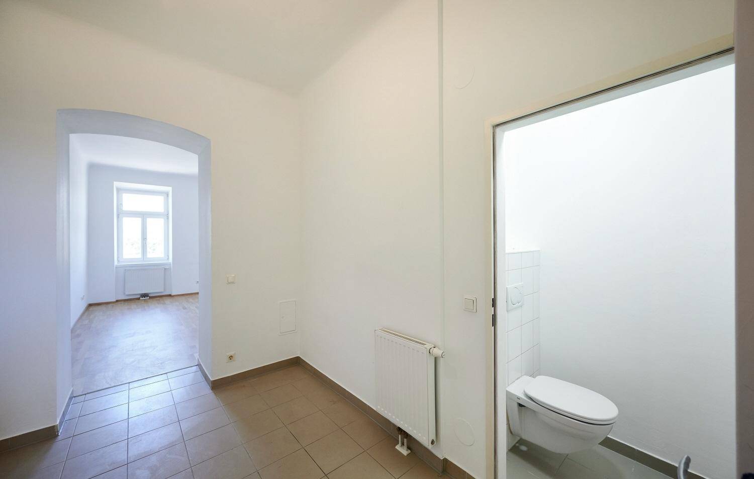 Flur mit Fliesenboden und Zugang zu einer separaten Toilette.