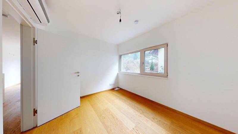Kleines, helles Zimmer mit Eichenparkettboden und Fenster, ideal als Kinder- oder Gästezimmer.