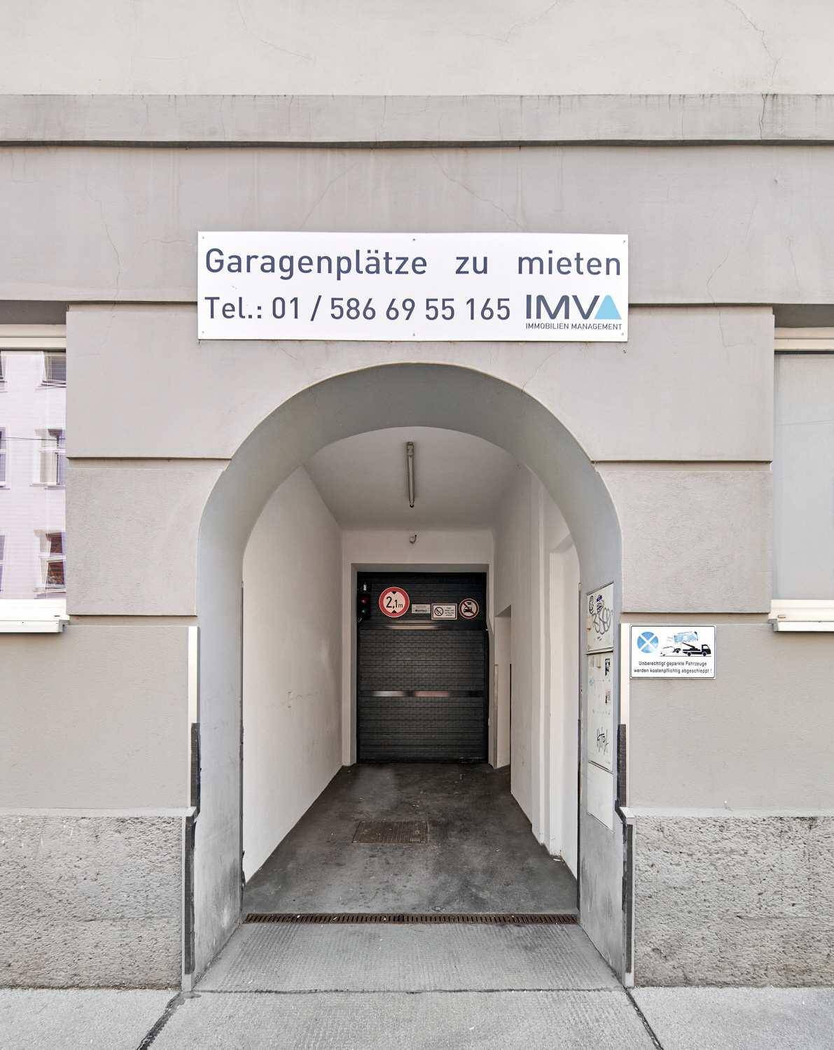 Eingang zu einer Tiefgarage mit einem Schild für Mietparkplätze.