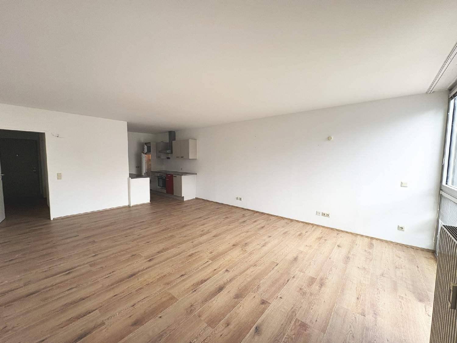 Geräumiger, heller Wohnbereich mit Laminatboden und integrierter Küchenzeile, ideal für offenes Wohnen.