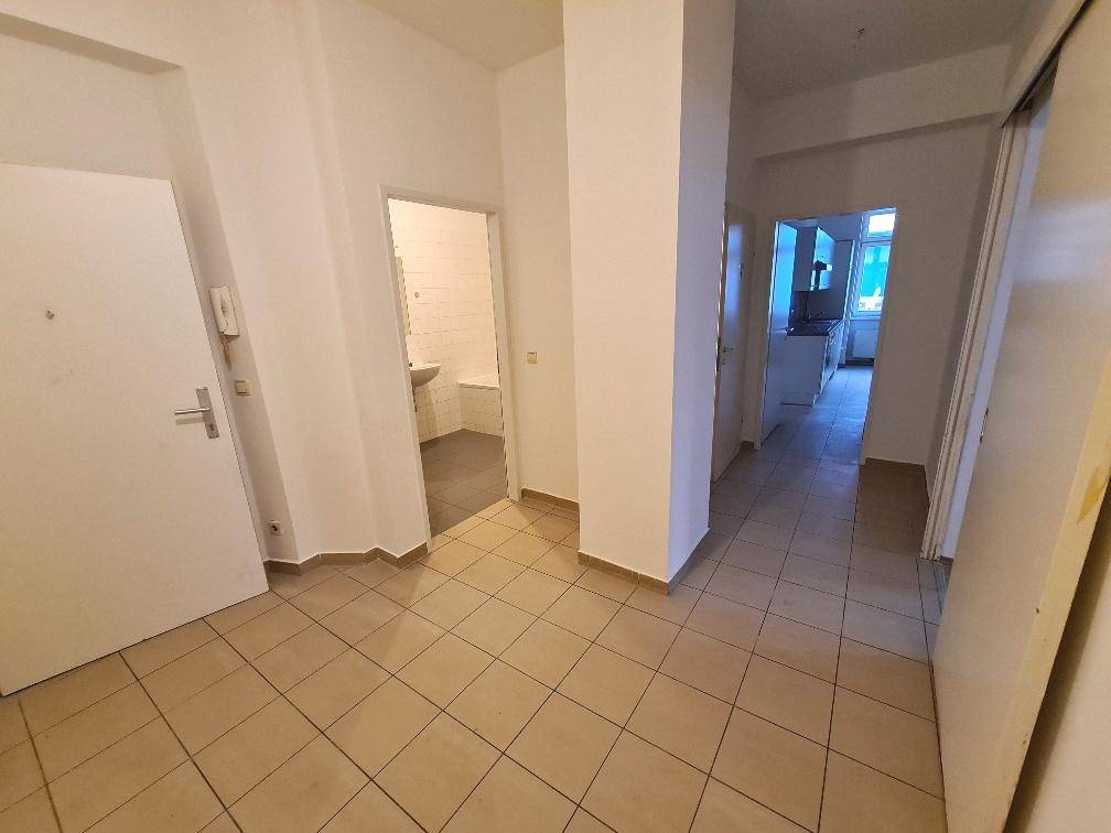 Geräumiger Flur mit hellen Fliesen, der Zugang zu verschiedenen Zimmern der Wohnung bietet.