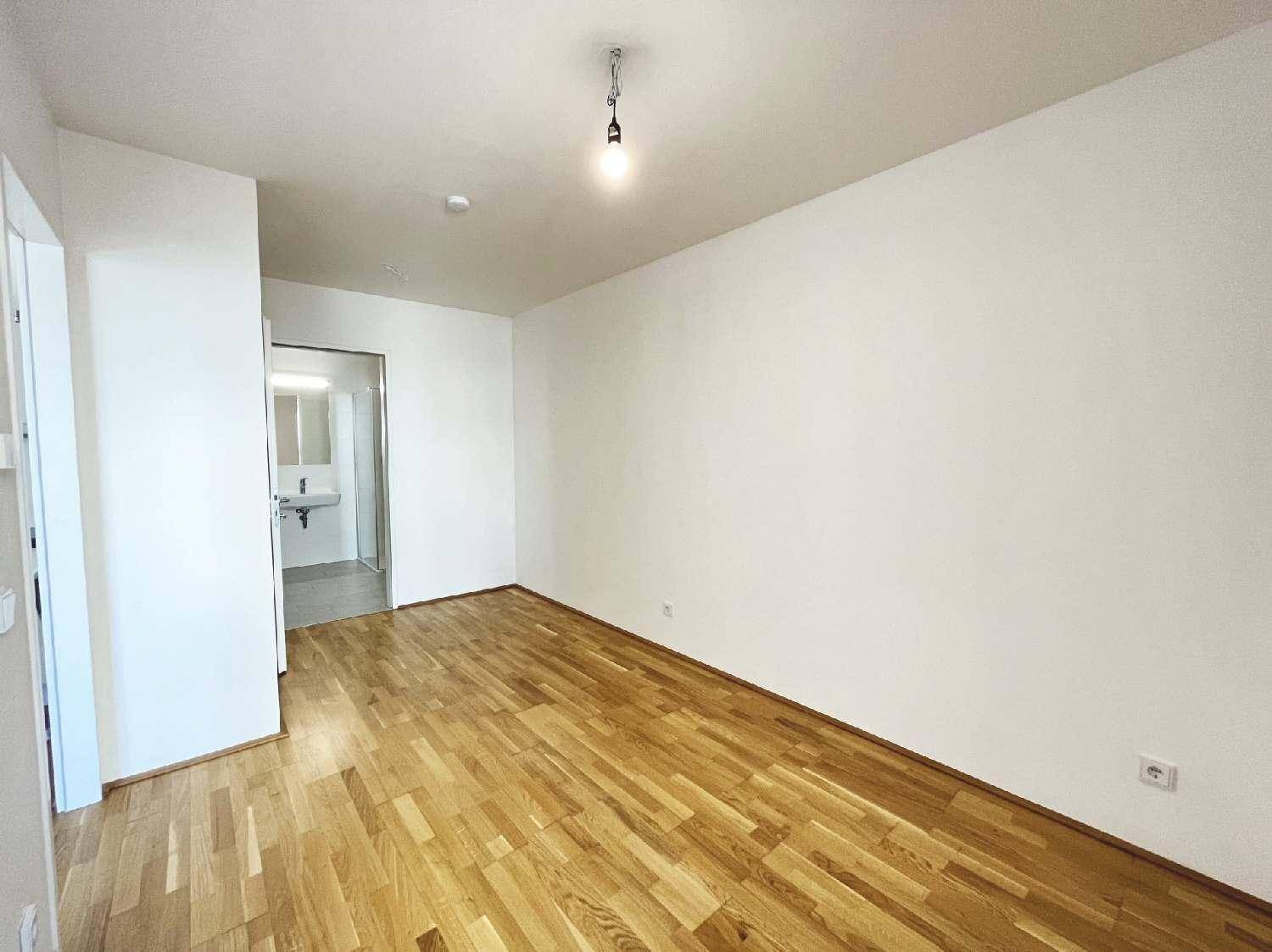 Geräumiges Zimmer mit Parkettboden und Blick auf das angrenzende Badezimmer.