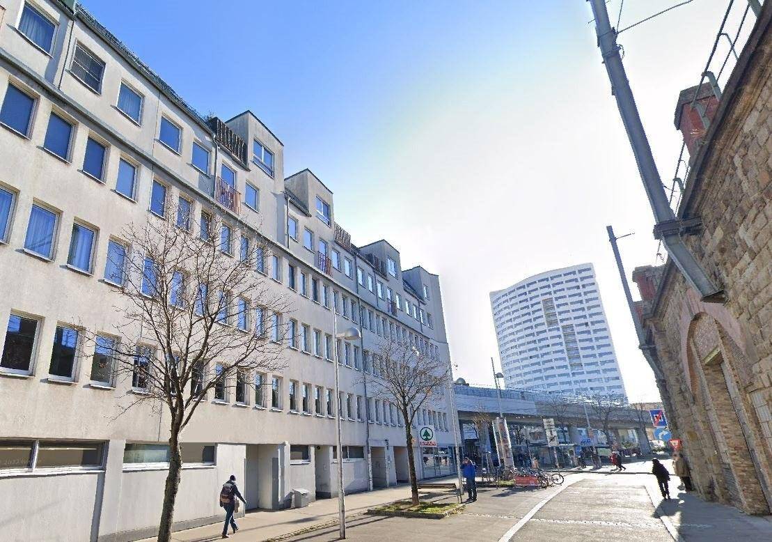 Ansicht eines modernen Gebäudes an einer Straße mit einem Supermarkt im Erdgeschoss.