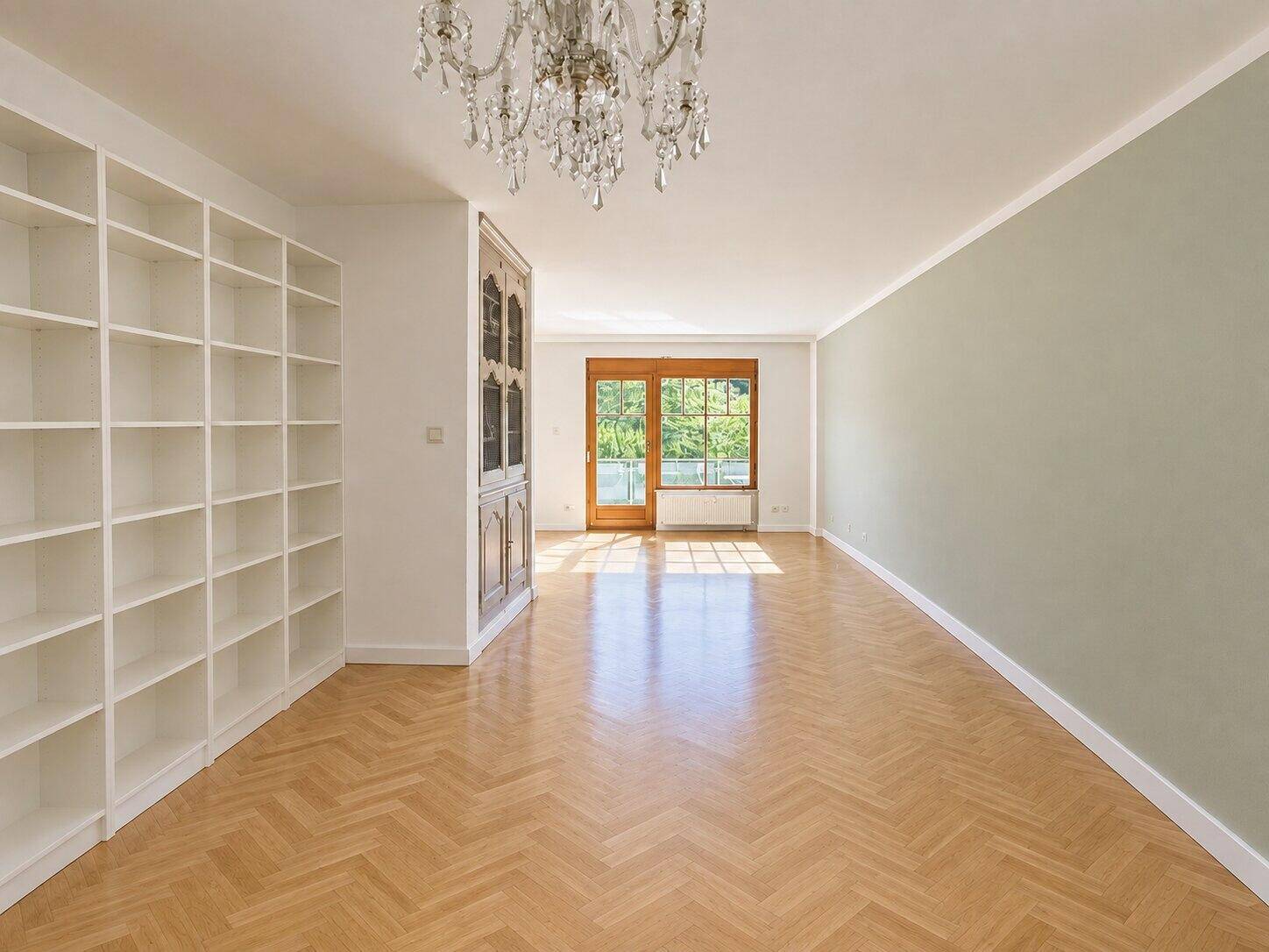 Helles Wohnzimmer mit Fischgrätparkett, hohen Decken und Zugang zu einem Balkon oder einer Terrasse.