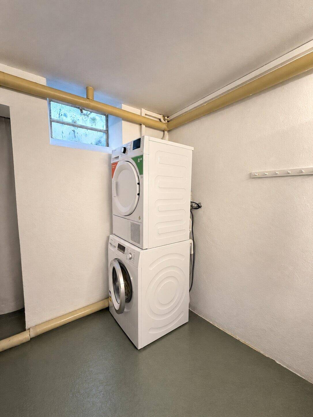Praktischer Hauswirtschaftsraum im Keller mit Waschmaschine und Trockner.