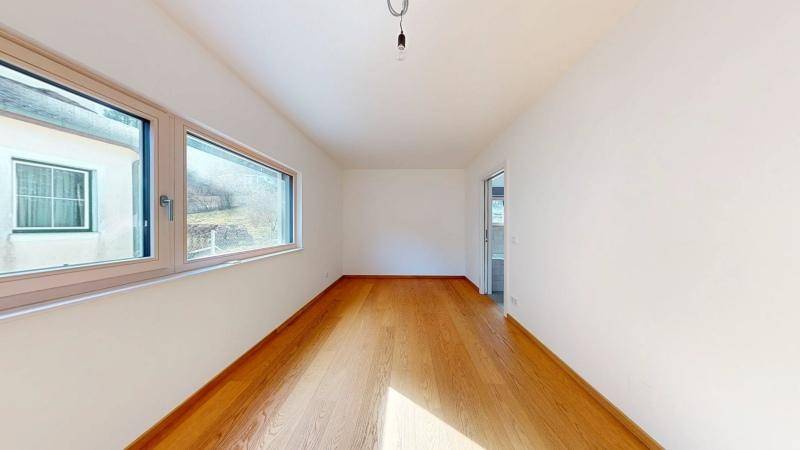 Helles Zimmer mit Eichenparkettboden und großen Fenstern, ideal als Schlaf- oder Arbeitszimmer.