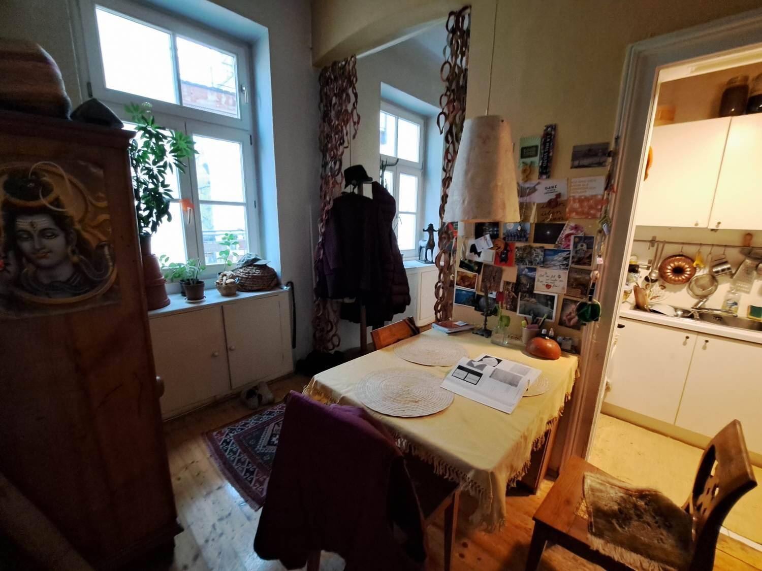 Essbereich mit Holzboden und Tisch, direkt neben dem Eingang zur Küche gelegen, mit natürlichem Licht.