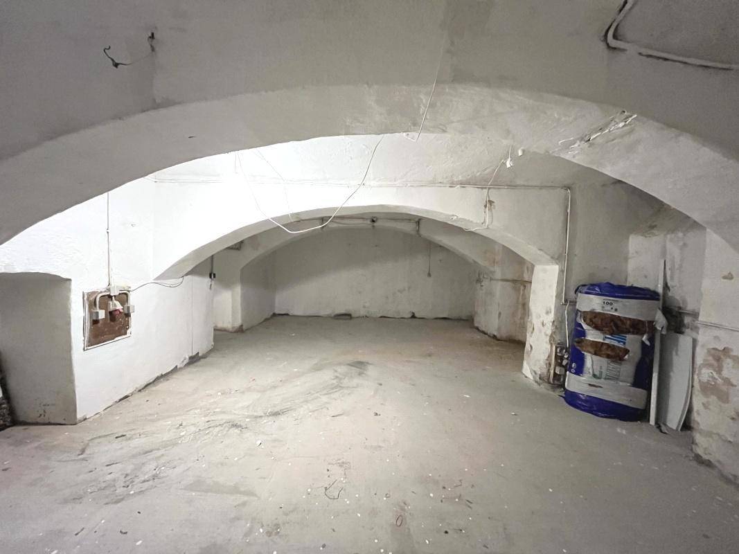 Geräumiger Kellerraum mit Gewölbedecke und Betonboden, bereit für Renovierung.