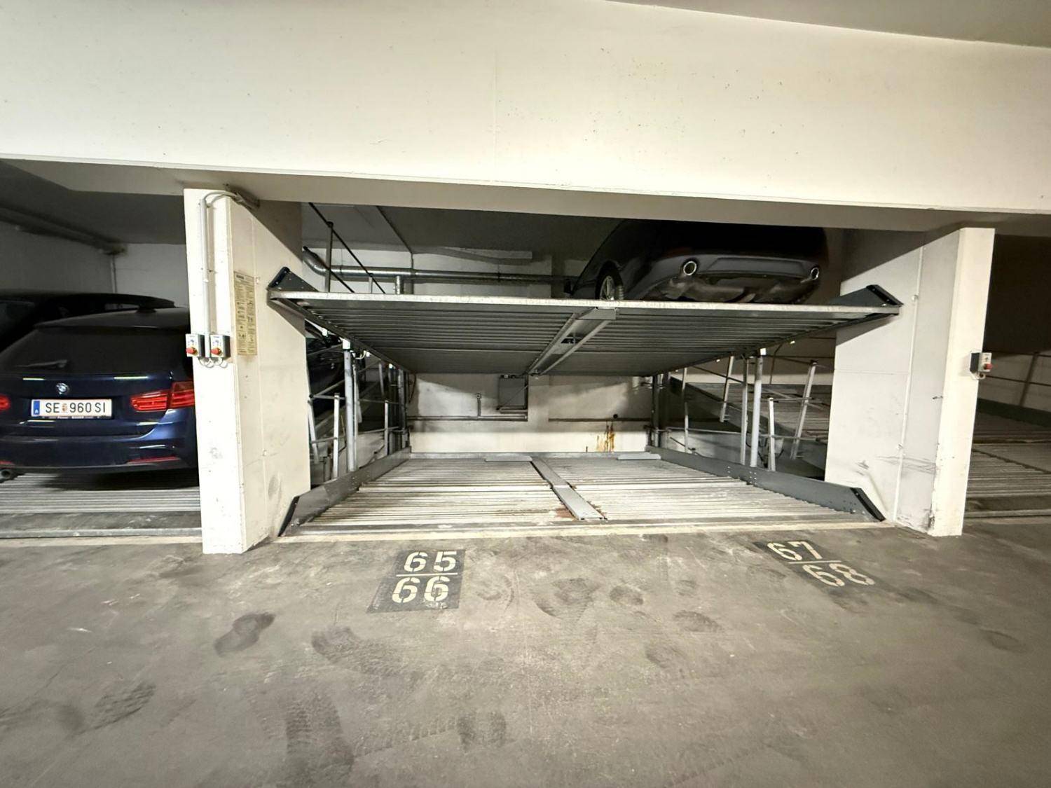 Detailansicht eines Doppelparker-Systems in einer Tiefgarage mit einem Fahrzeug auf der oberen Plattform.