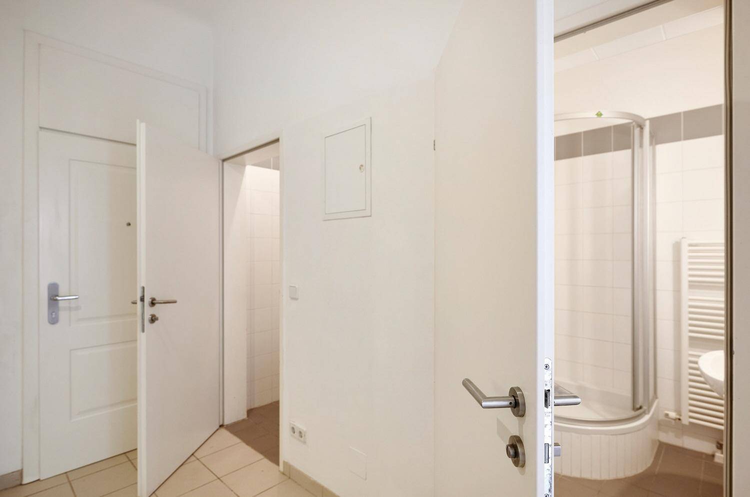 Heller Flur mit Zugang zu verschiedenen Räumen, inklusive dem Badezimmer.