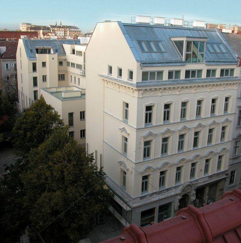 Historisches Gebäude mit modernem Dachausbau und einem weiten Blick über die Stadtlandschaft.