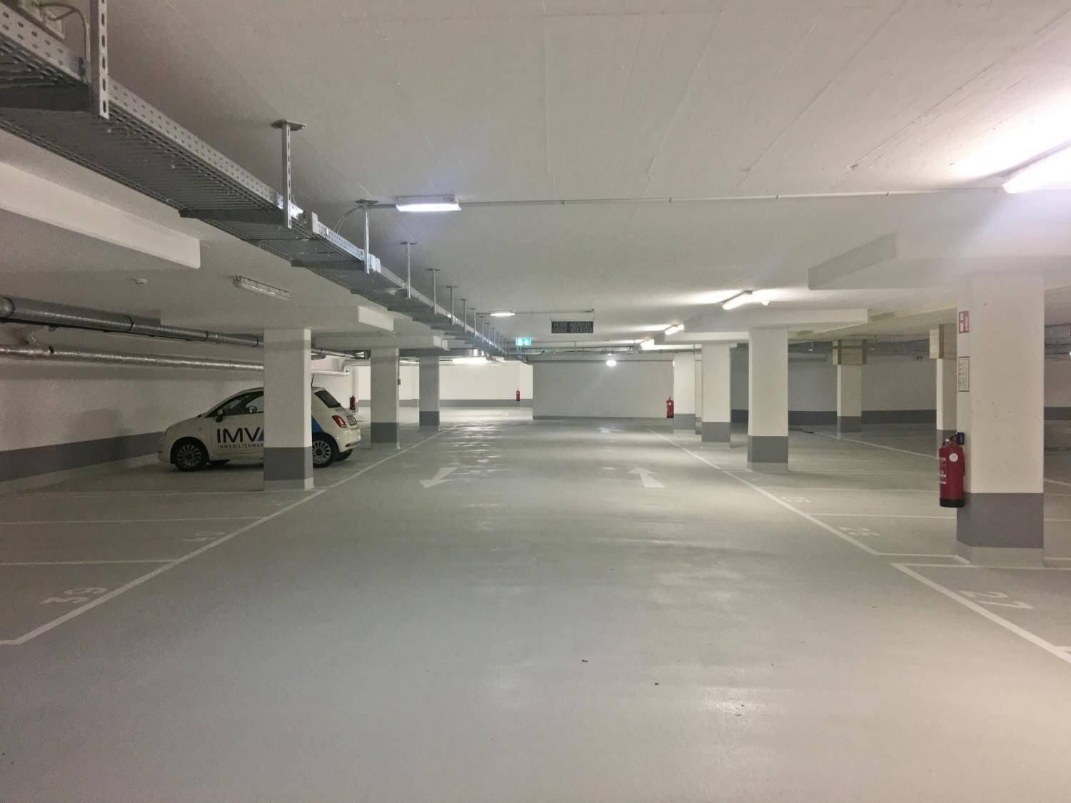 Geräumige Tiefgarage mit vielen Stellplätzen, guter Beleuchtung und klaren Markierungen.