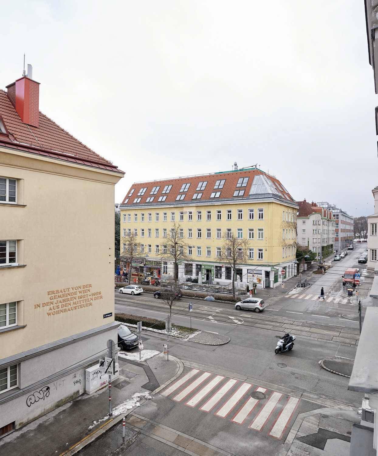 Blick auf eine belebte Stadtstraße mit Gebäuden und Verkehr.
