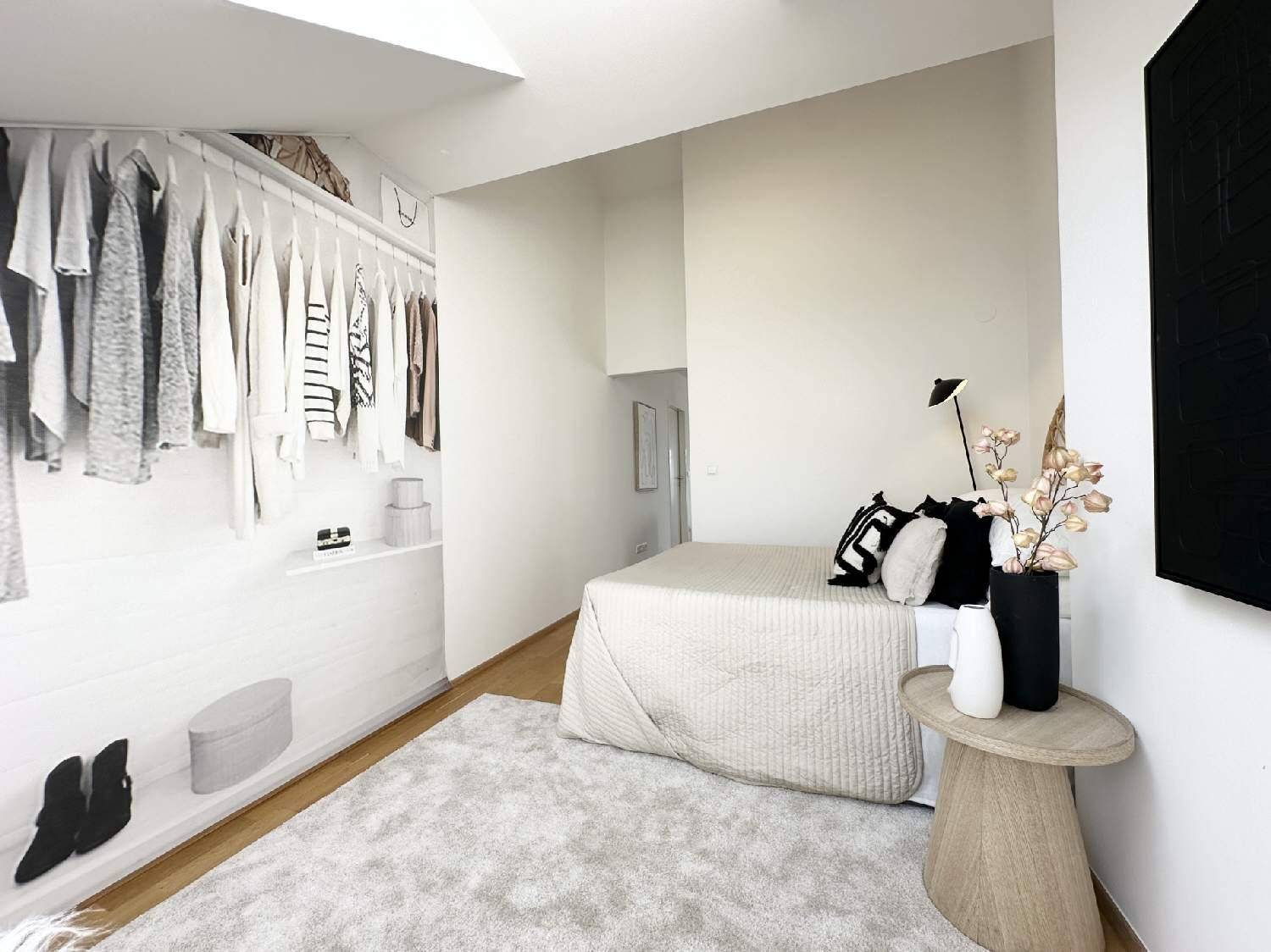 Modernes Schlafzimmer mit Teppichboden und offenem Kleiderschrankbereich für Kleidung.