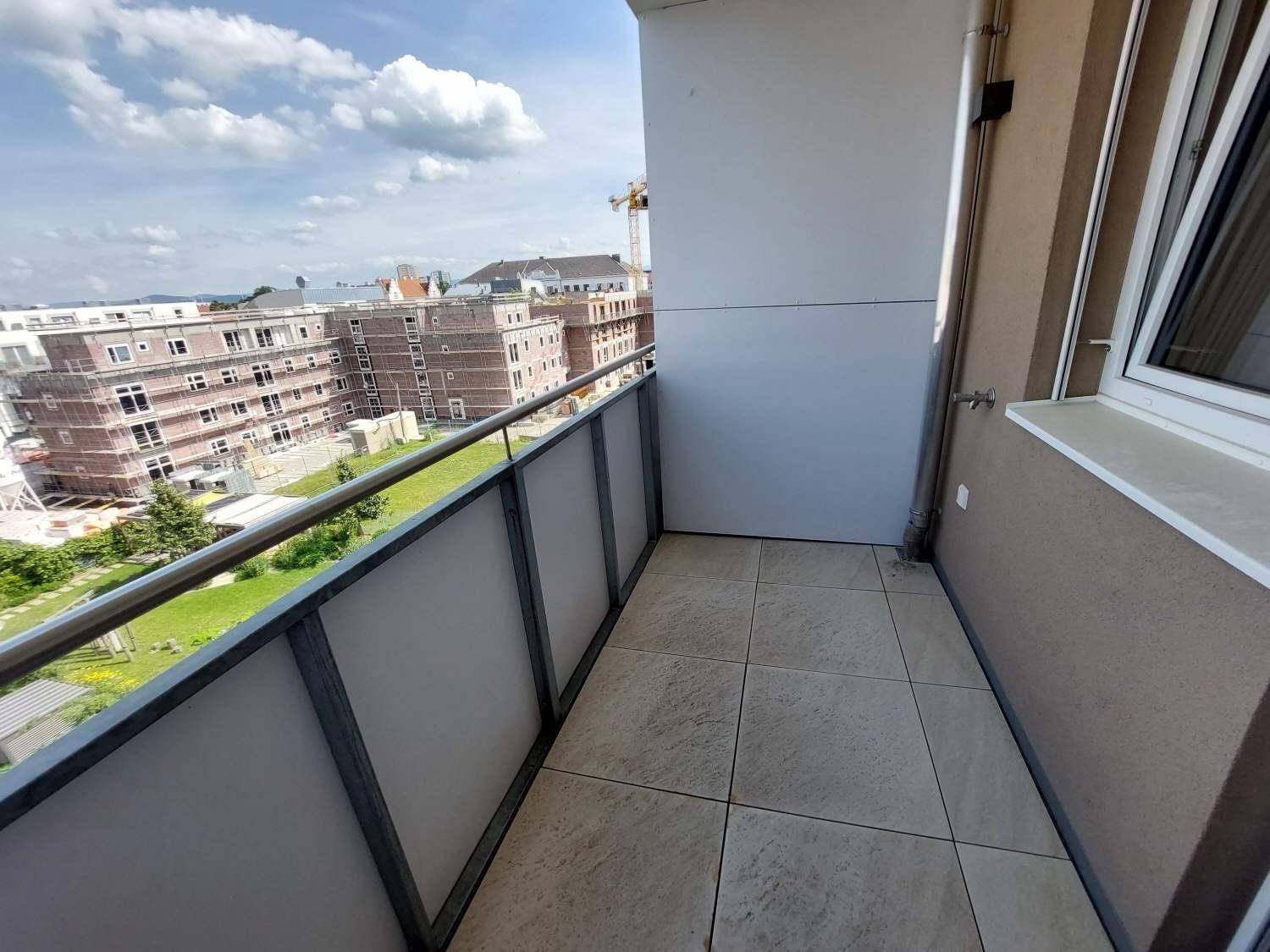 Kleiner Balkon mit Fliesenboden und Blick auf die umliegenden Gebäude.