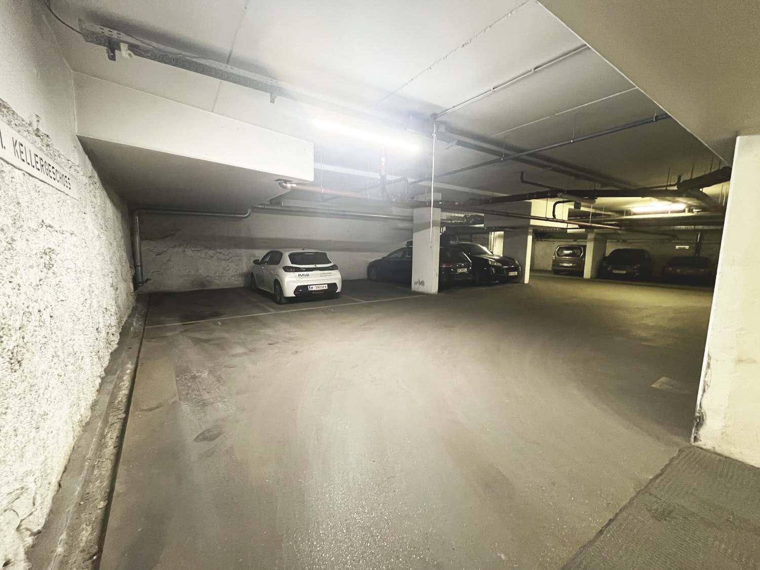 Geräumige Tiefgarage mit mehreren Stellplätzen und heller Beleuchtung.