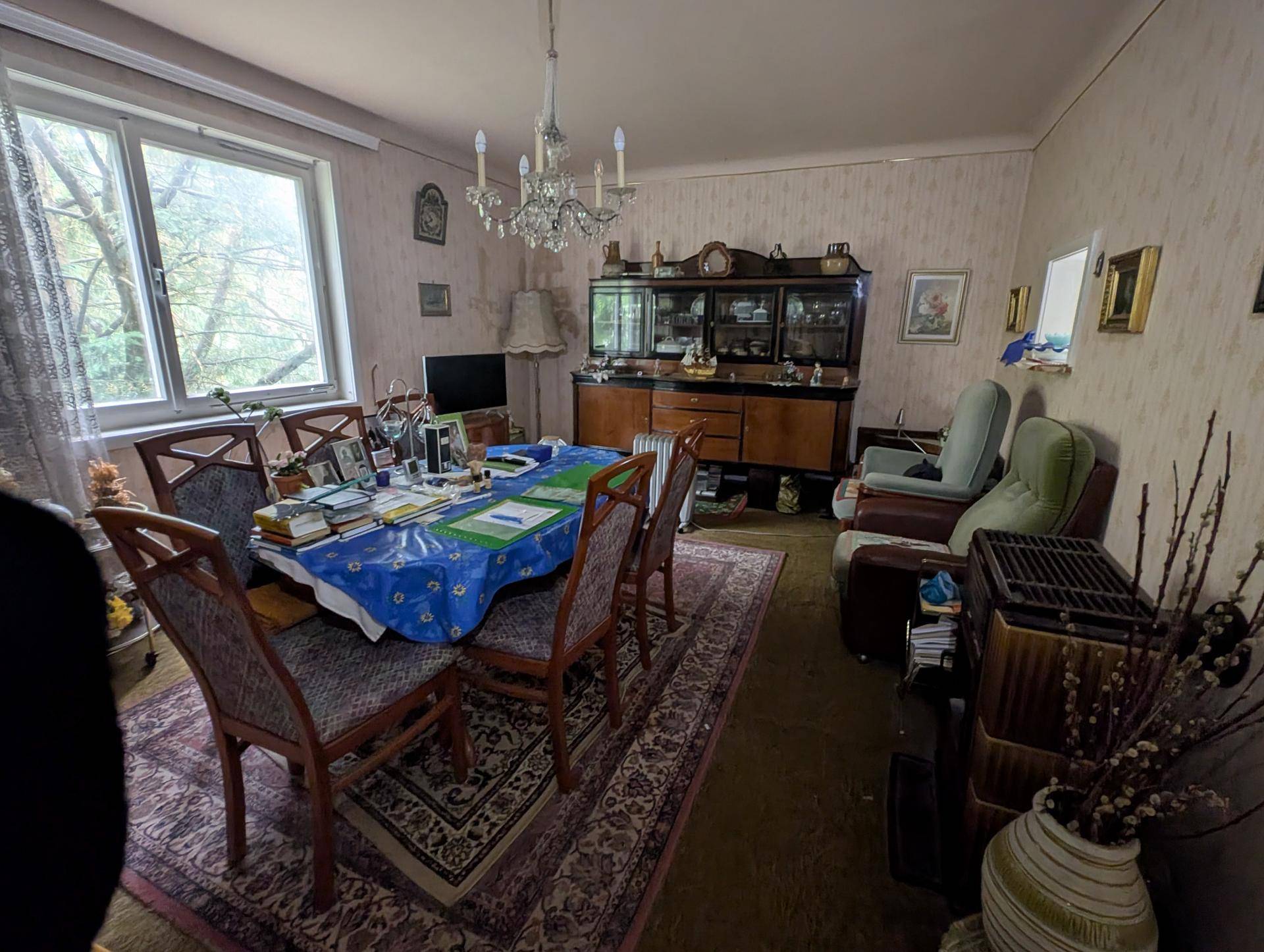 Traditionelles Esszimmer mit großem Holztisch, antiken Möbeln und einem dekorativen Kachelofen.