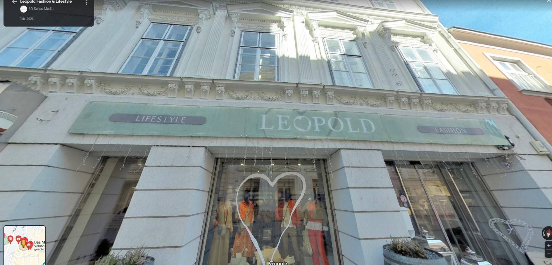 Fassade eines historischen Gebäudes mit großen Fenstern und dem Schriftzug 'LEOPOLD' über dem Eingangsbereich.
