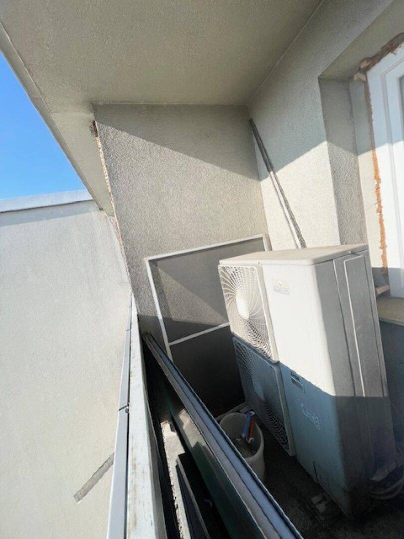 Kleiner Balkon mit Klimaanlage und Blick auf die Umgebung.