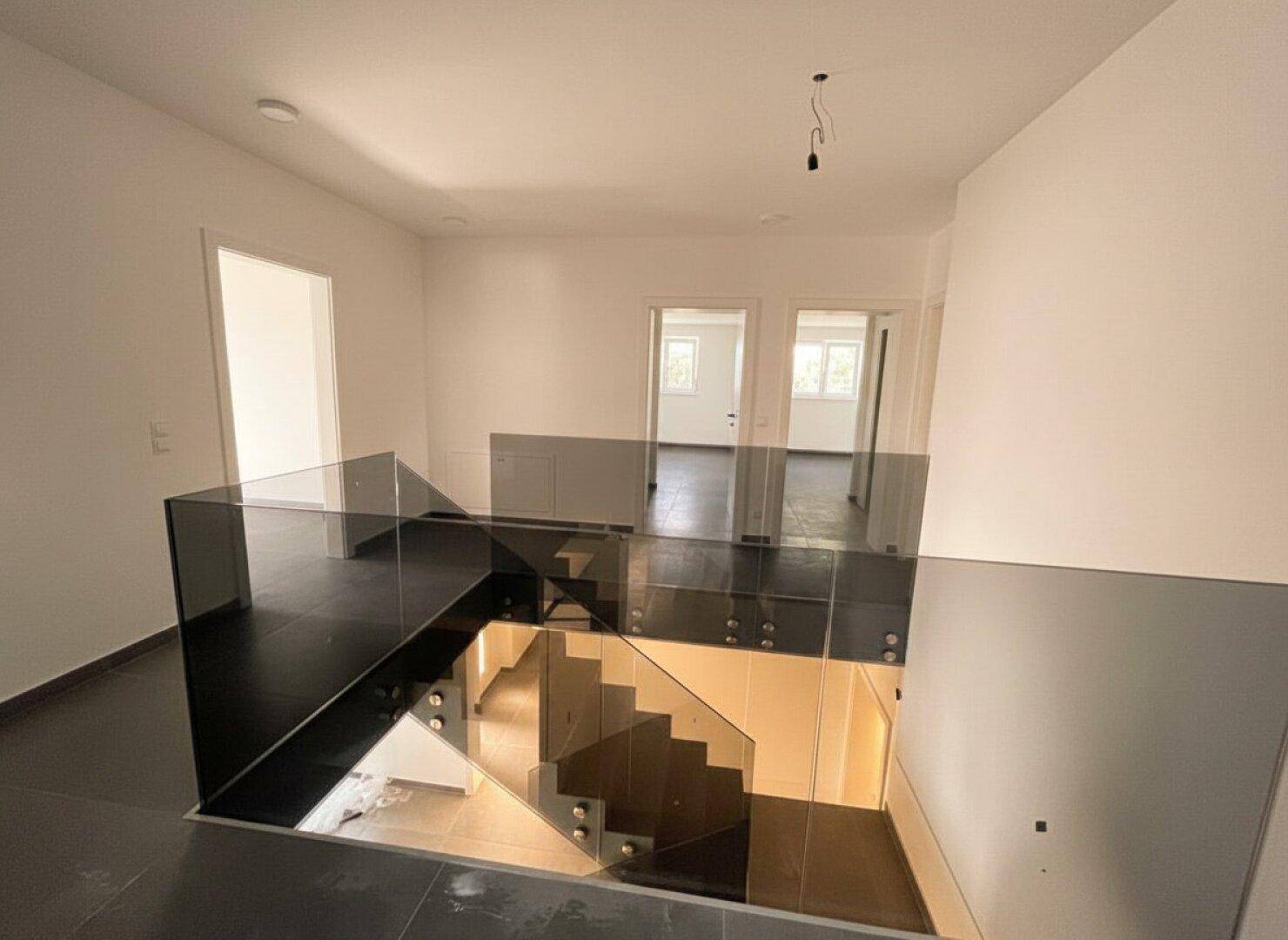 Offener Flurbereich im Obergeschoss mit Blick auf die Treppe und weitere Zimmer.