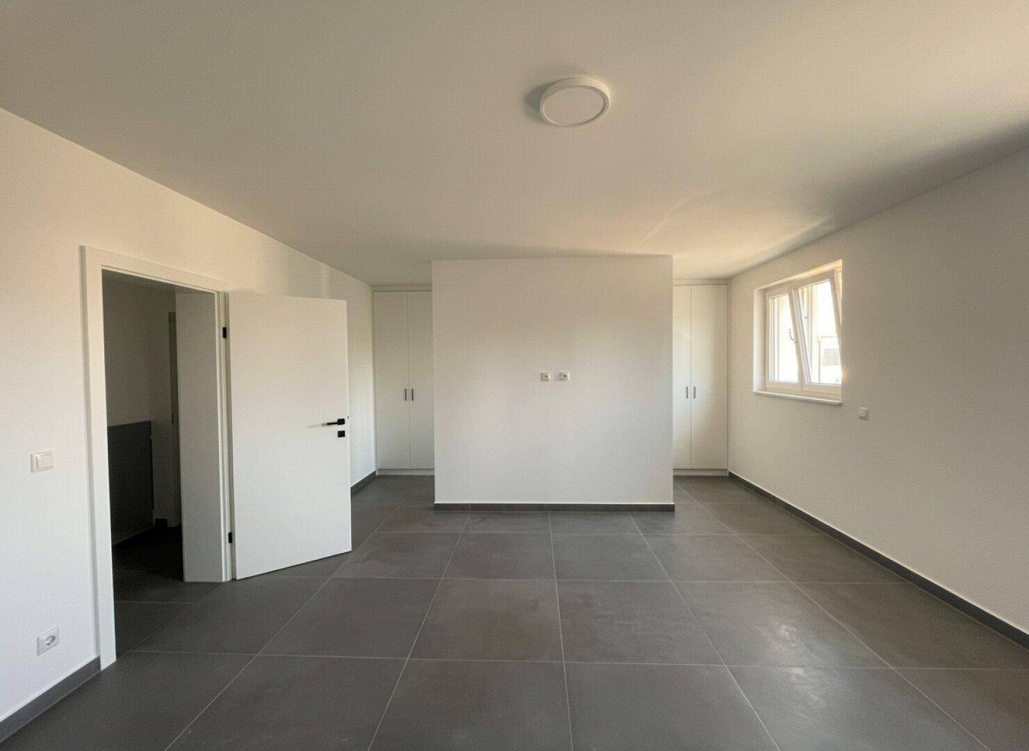 Geräumiges Schlafzimmer mit viel Tageslicht und integrierten Schränken, bereit zur individuellen Gestaltung.