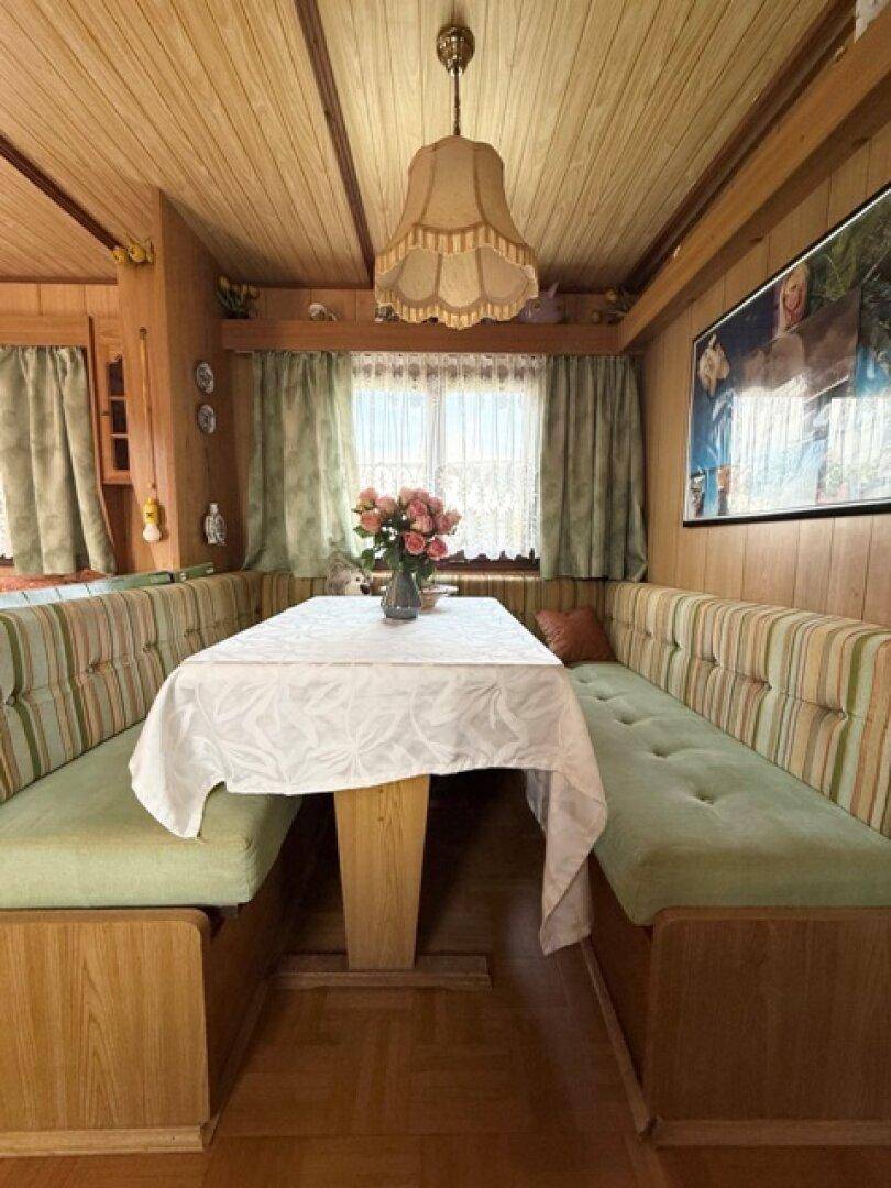 Essbereich mit Holzvertäfelung, Eckbank und einem gedeckten Tisch.