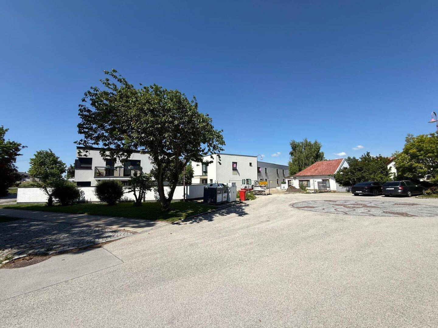 Panoramablick auf die Umgebung mit modernen Gebäuden, Bäumen und einem weiten Himmel.