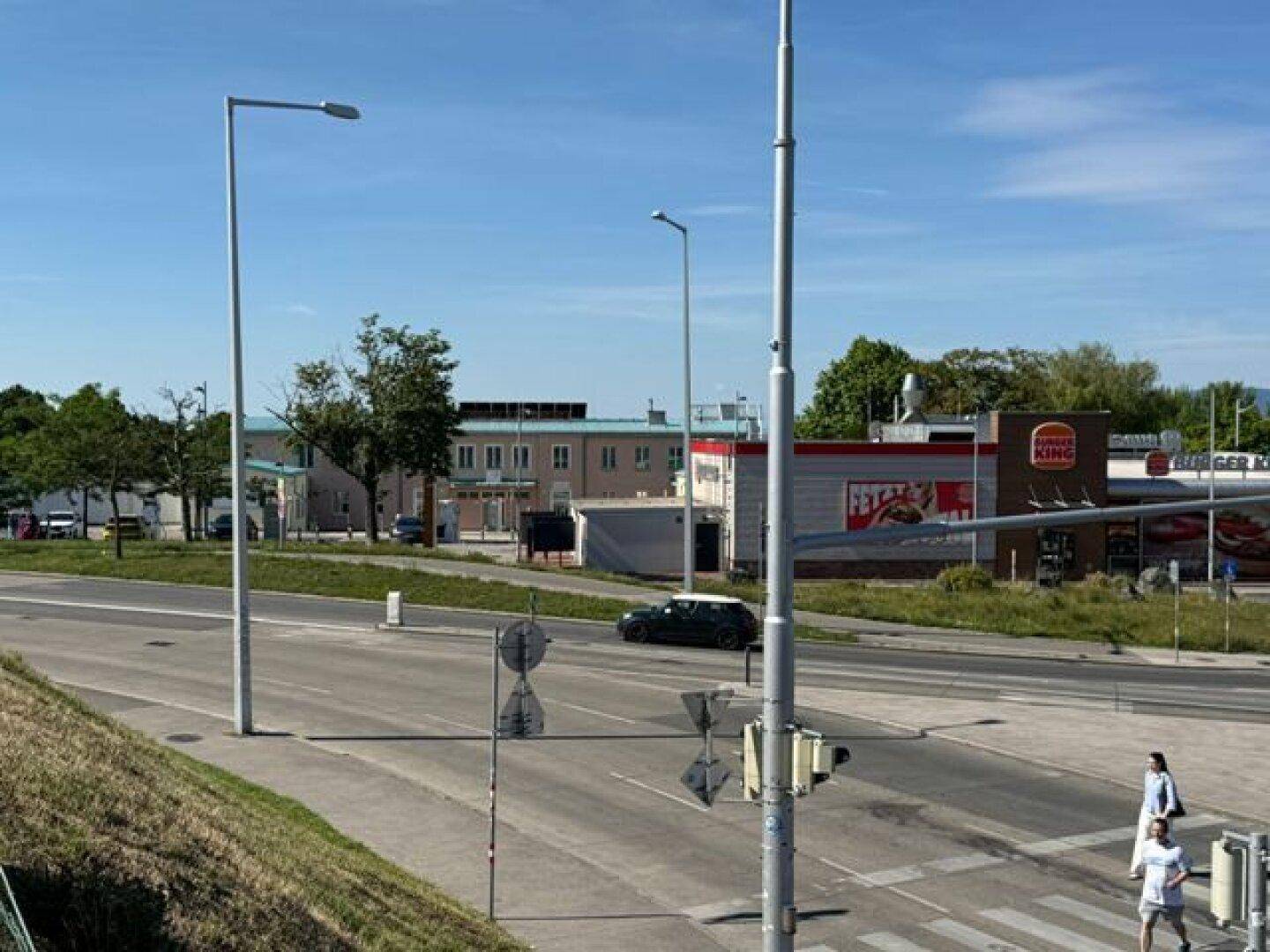 Blick auf die Umgebung mit Schnellrestaurant, Straße und umliegenden Gebäuden bei Tageslicht.