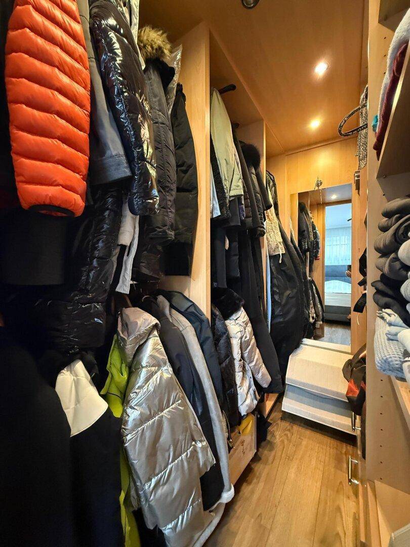 Geräumiger begehbarer Kleiderschrank mit Hängestangen und Regalen für Kleidung.