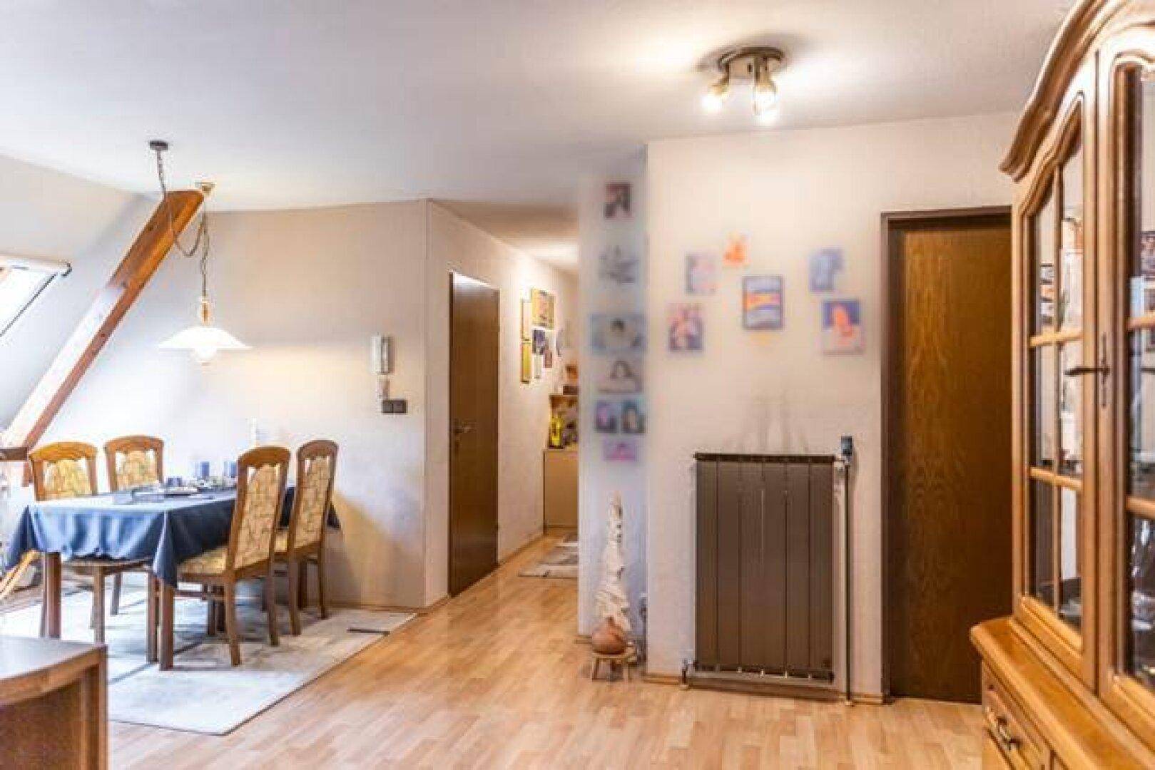 Essbereich in einer Dachgeschosswohnung mit Esstisch und Dachfenster.