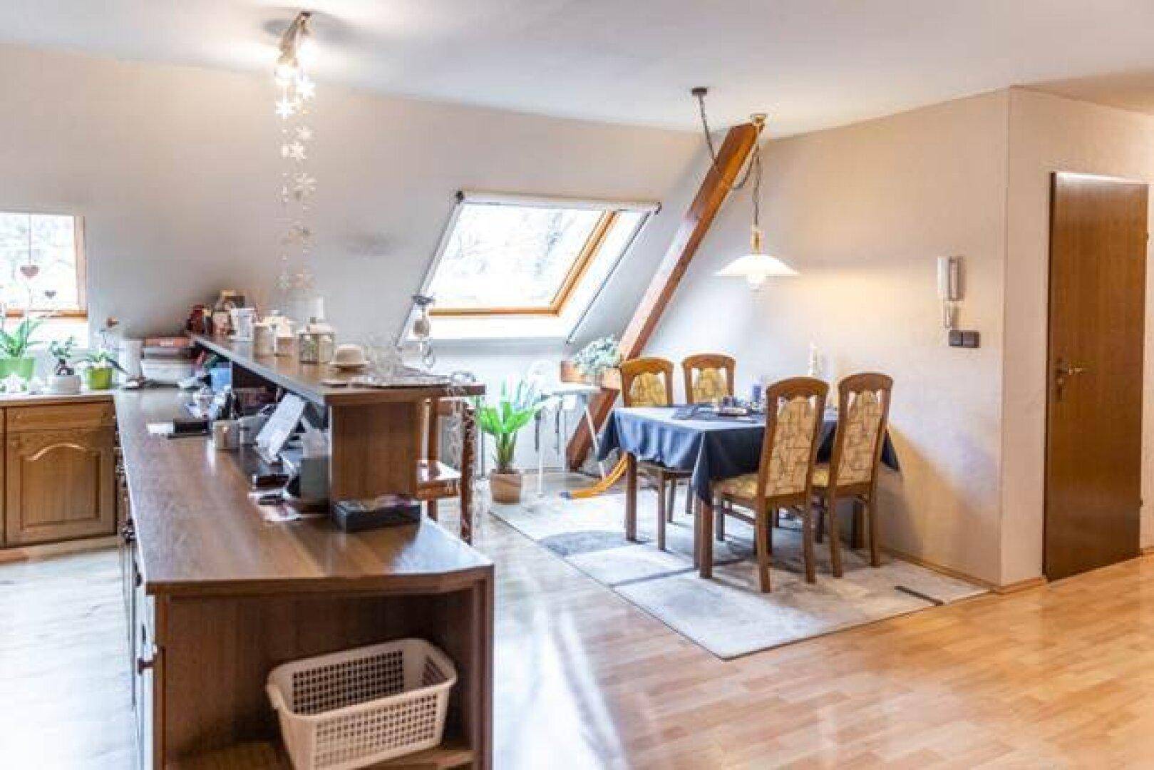 Offener Wohn- und Essbereich mit Bar und Dachfenster in der Dachgeschosswohnung.