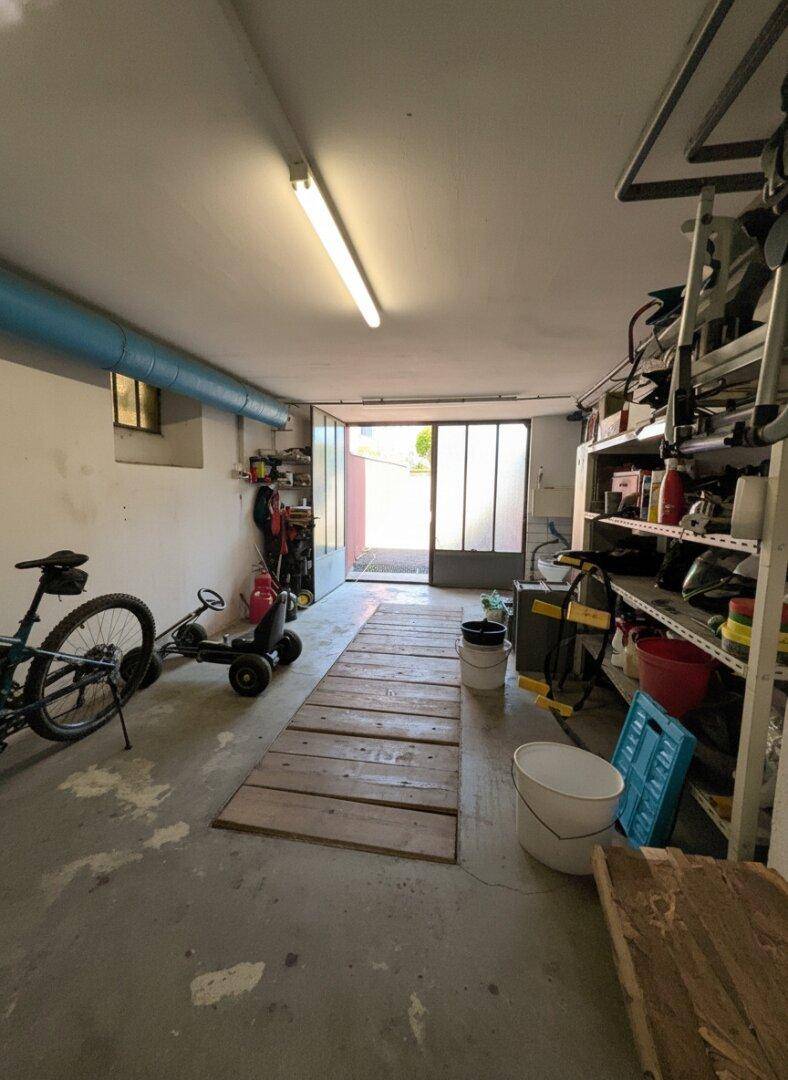 Geräumige Garage mit Werkstattbereich und Zugang zum Außenbereich, ideal für Hobby und Fahrzeuge.