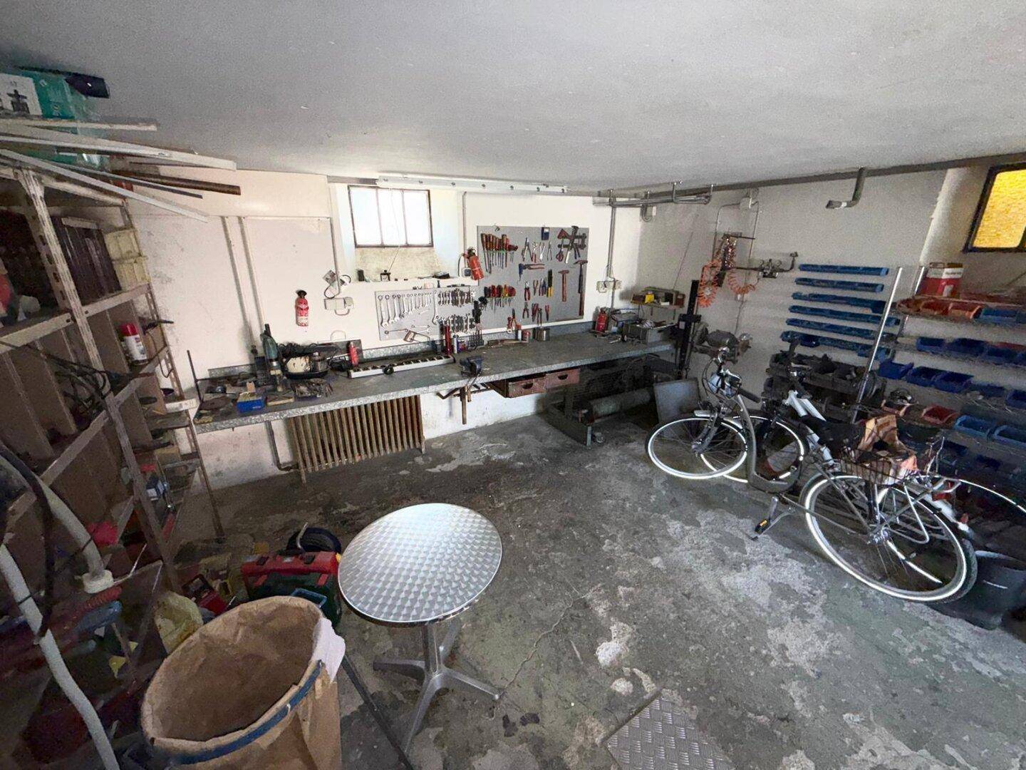 Gut ausgestattete Werkstatt mit vielen Werkzeugen und Arbeitsflächen, ideal für handwerkliche Tätigkeiten.