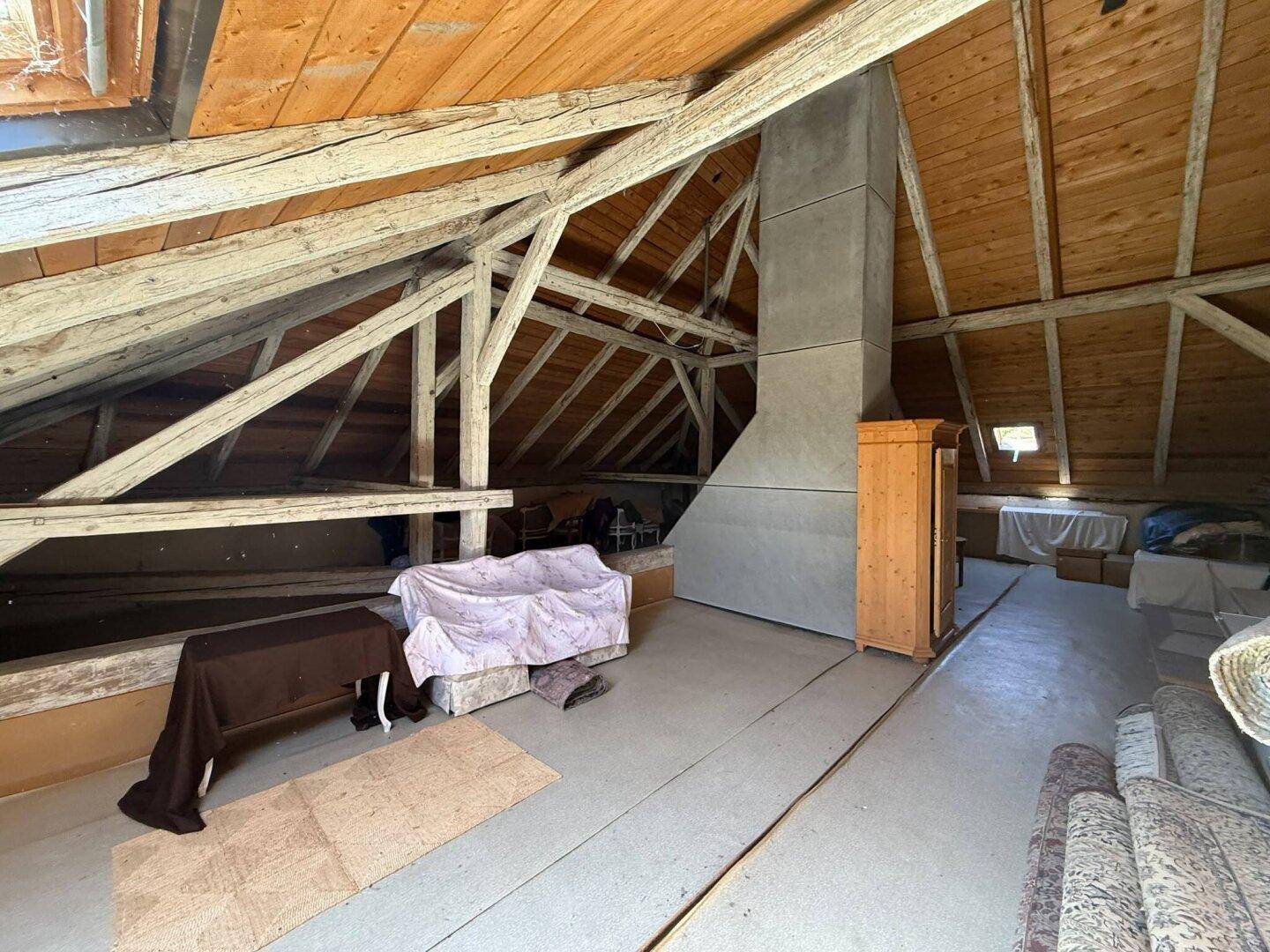 Großer Dachbodenbereich mit charakteristischen Holzbalken und schräger Holzdecke.