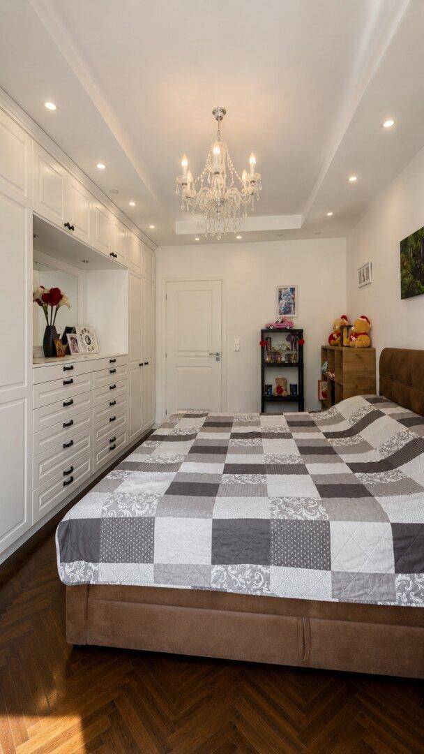 Geräumiges Schlafzimmer mit großem Bett, Einbauschränken und elegantem Kronleuchter.