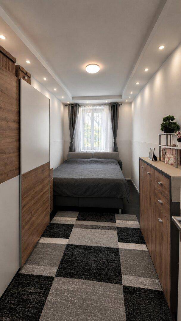 Kompaktes Schlafzimmer mit Doppelbett, Kleiderschrank und Kommode, gut beleuchtet.