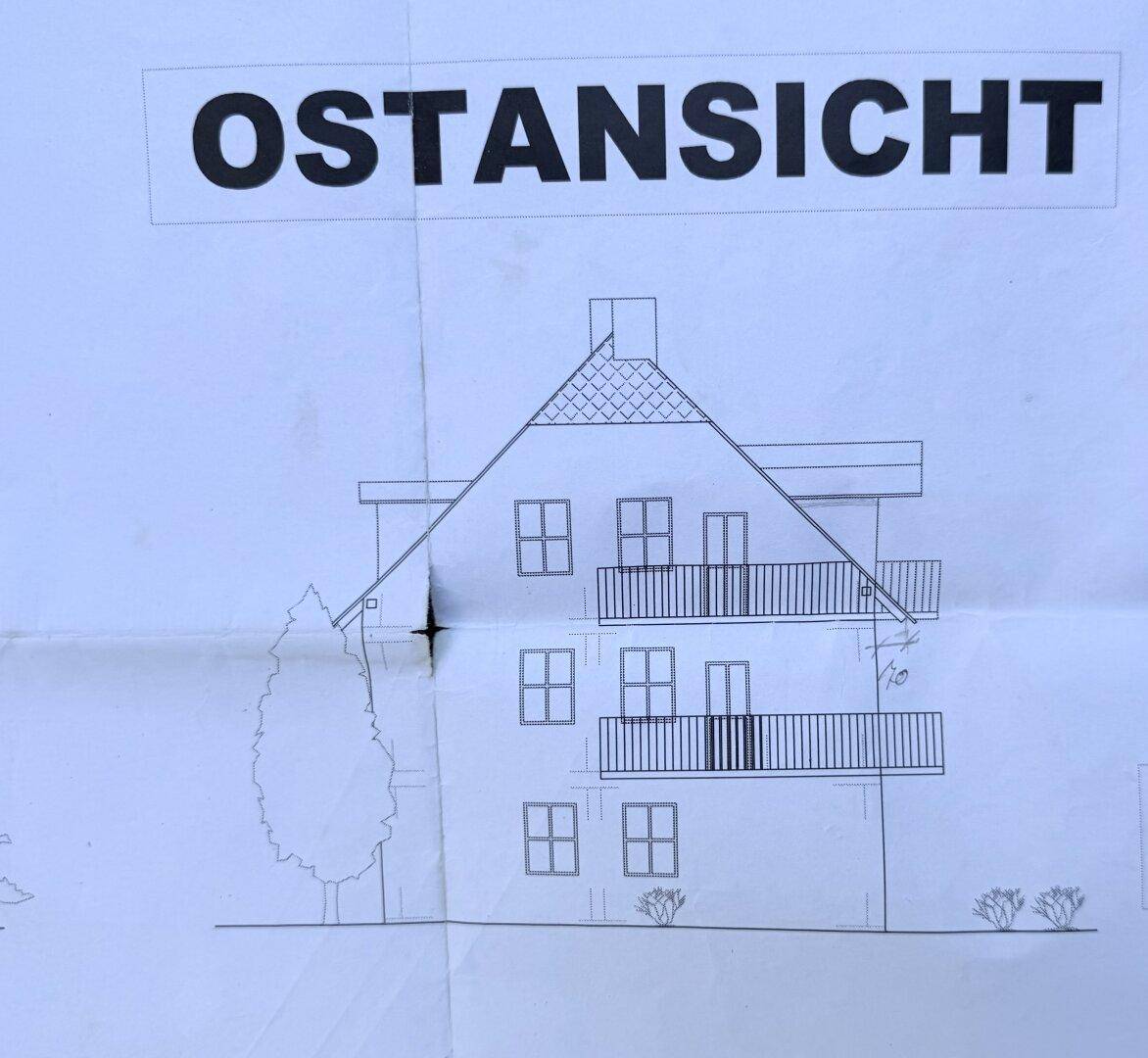 Ostansicht des Gebäudes mit Balkonen und Giebeldach.