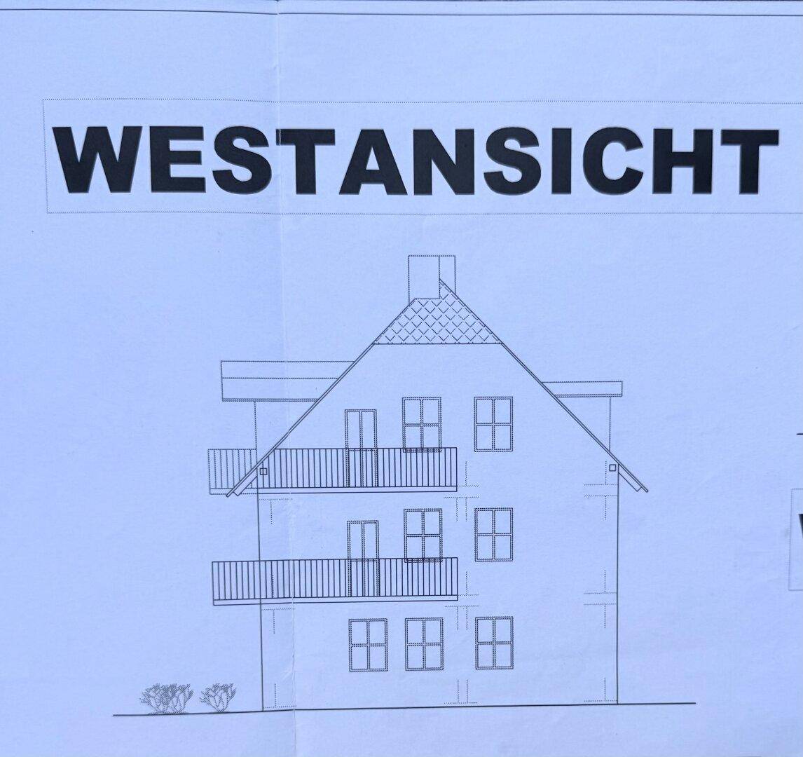 Westansicht des Gebäudes mit Balkonen und Giebeldach.