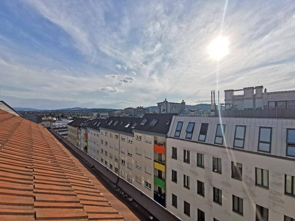 Panoramablick über die Dächer der Stadt an einem sonnigen Tag mit weitem Horizont.