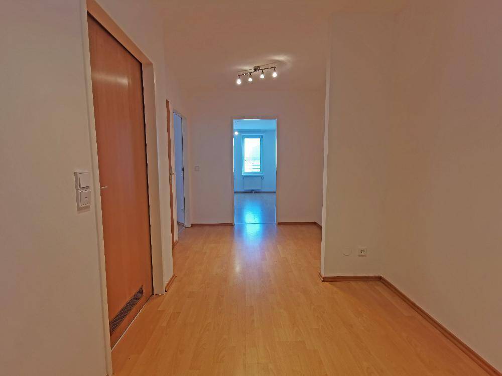 Länglicher Flur mit Parkettboden und Blick in einen weiteren Raum, sorgt für eine offene Atmosphäre.