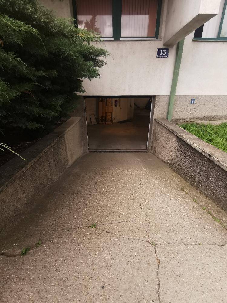 Betonrampe führt zur Tiefgarage eines Mehrfamilienhauses.
