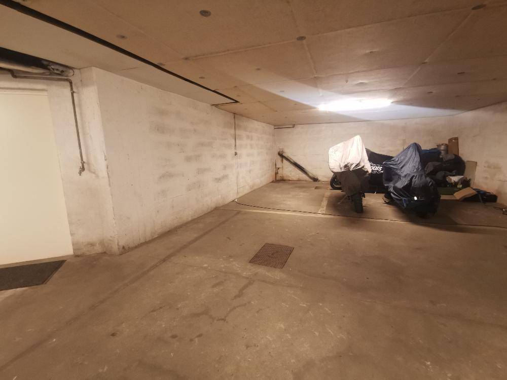 Helle Tiefgarage mit Betonboden und Platz für mehrere Fahrzeuge.