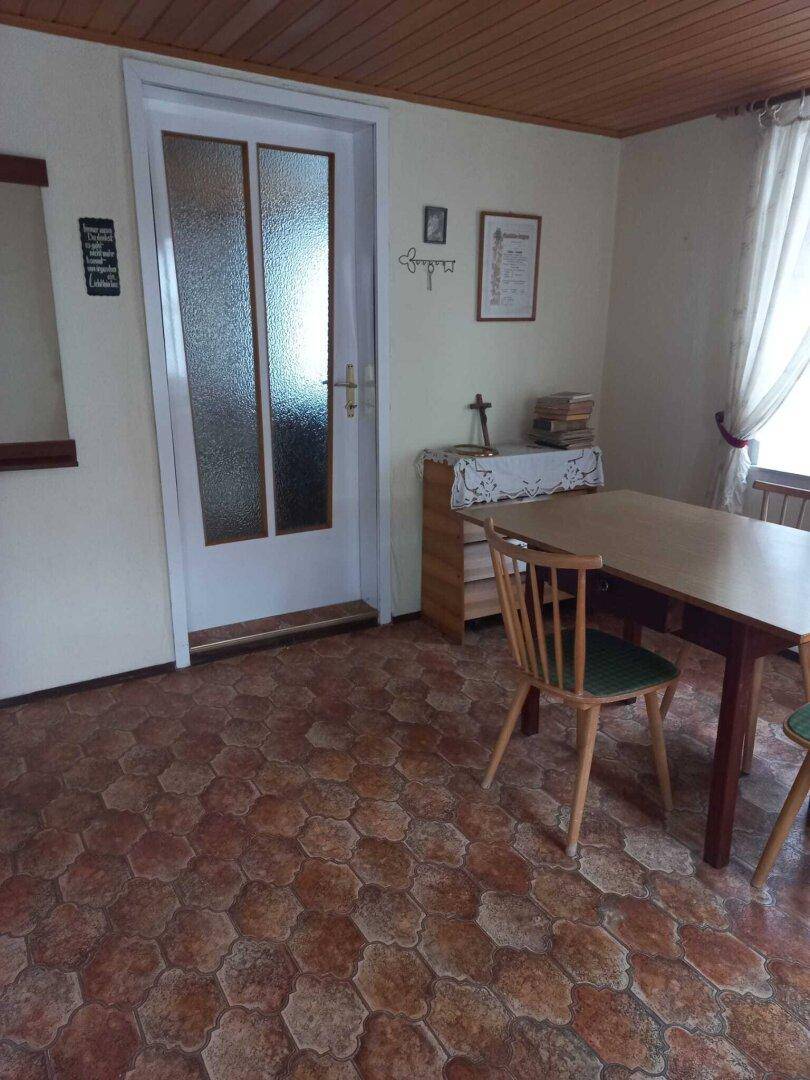 Gemütlicher Essbereich mit Holztisch, Stühlen und einem gemusterten Fliesenboden.