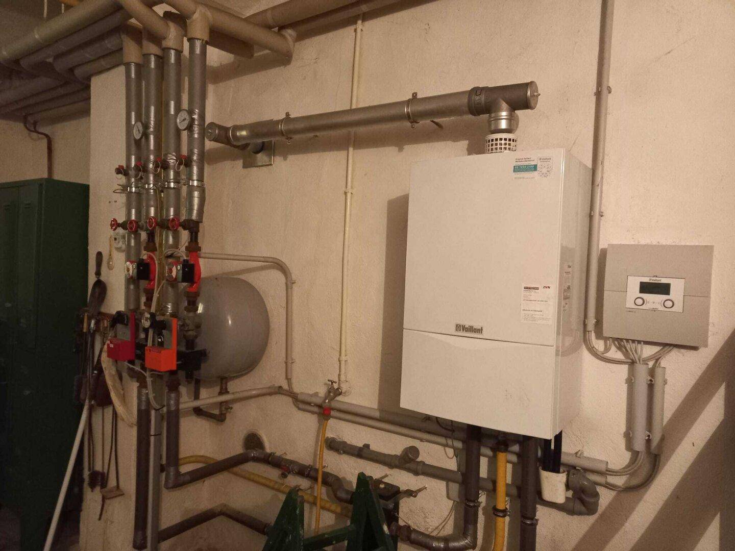 Heizungsraum mit moderner Gastherme und komplexen Rohrleitungen für die Wärmeversorgung.
