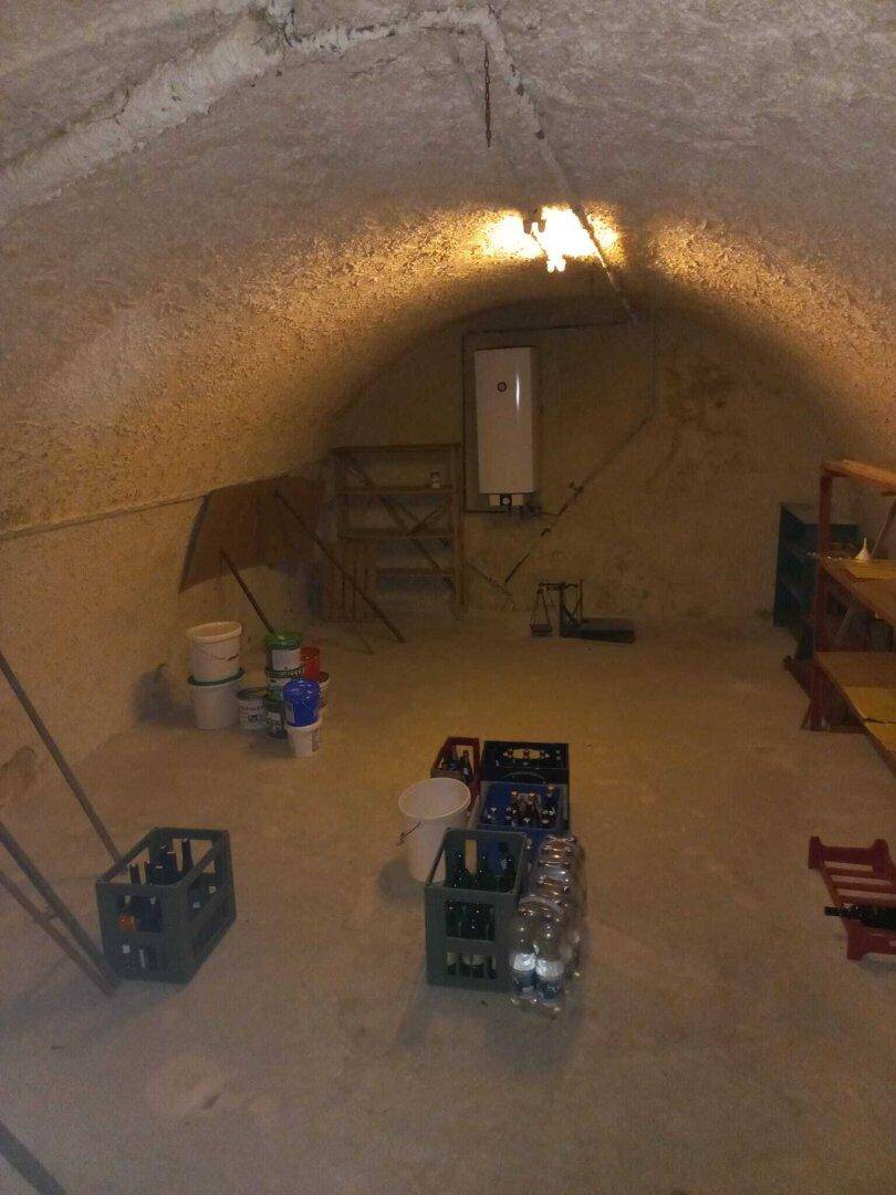 Geräumiger Kellerraum mit gewölbter Decke, ideal zur Lagerung von Vorräten und Getränken.